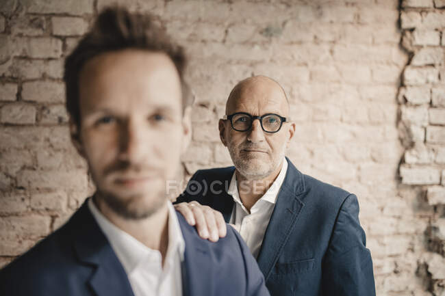 Portrait of senior businessman behind and mid-adult businessman — Stock Photo