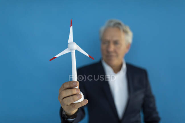 Hombre de negocios senior sosteniendo modelo de turbina eólica - foto de stock