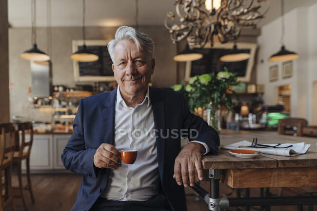 Ritratto di anziano uomo d'affari che beve espresso in un caffè — Foto stock