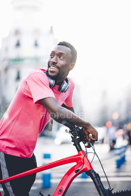 Happy young man with e bike in the city — Stock Photo