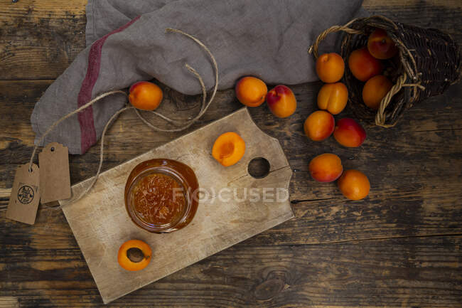 Абрикосовое варенье и абрикосы на темной древесине — стоковое фото