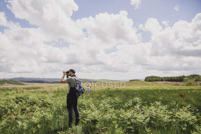Padre e hijo observando aves, Escocia, Reino Unido - foto de stock