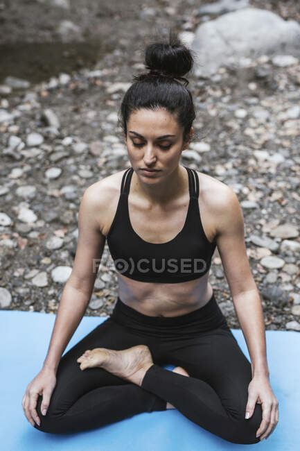 Mulher praticando ioga meditando na cachoeira — Fotografia de Stock