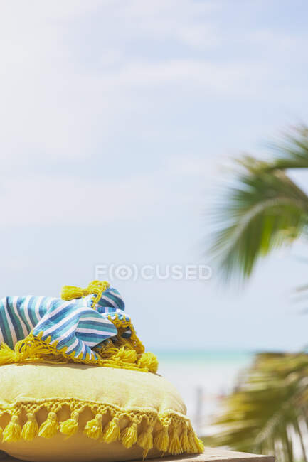 Almohada tradicional y manta en la playa con palmeras en el fondo, Holbox, Yucatán, México - foto de stock
