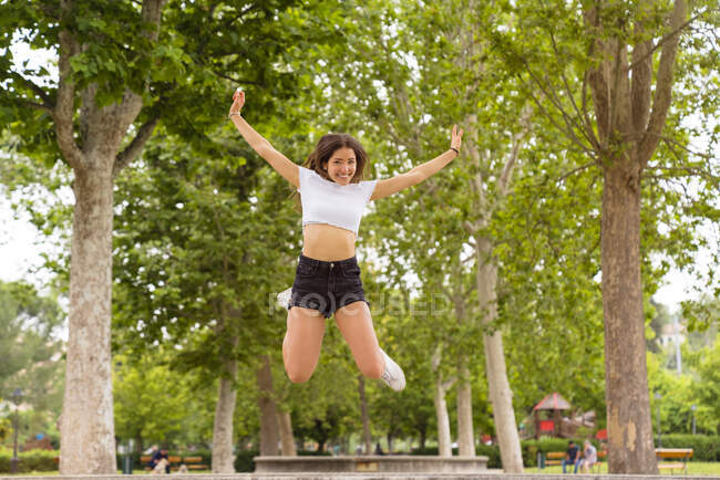 Giovane donna che salta nel parco — Foto stock