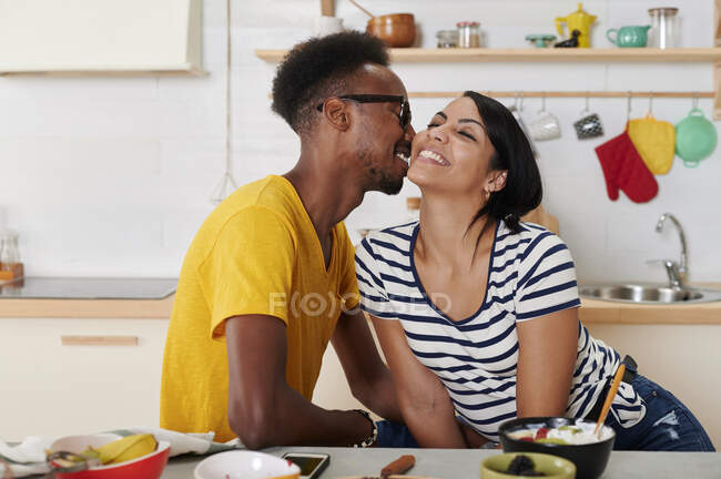 Мультиетнічна пара відпочиває разом на кухні. — стокове фото