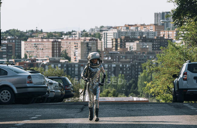 Boy dressed as an astronaut walking on a street in the city — Stock Photo
