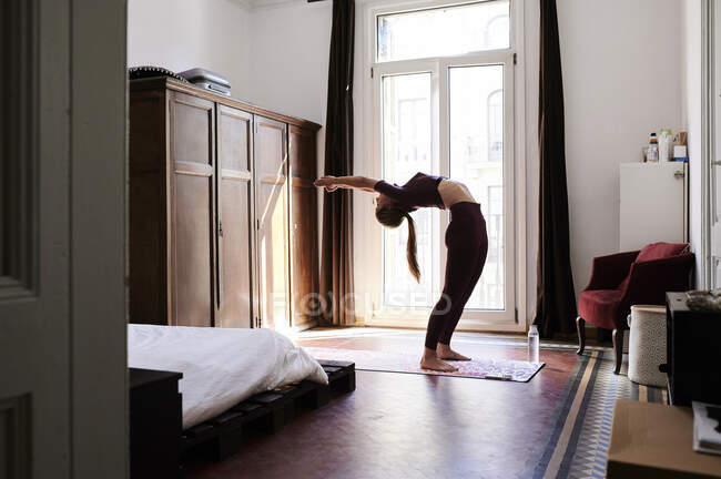 Молодая брюнетка практикует йогу в студенческом общежитии — стоковое фото