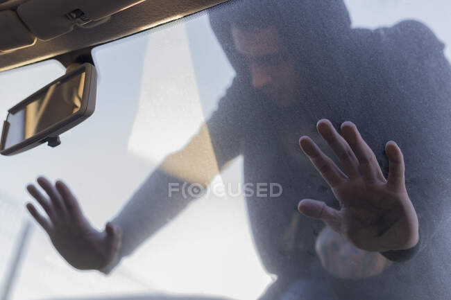 Jovem apoiado no pára-brisas de um carro velho no ferro velho — Fotografia de Stock
