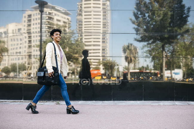 Frau mit Laptoptasche zu Fuß — Stockfoto