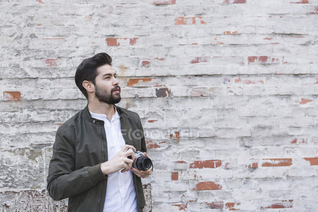 Barbuto giovane uomo con macchina fotografica — Foto stock