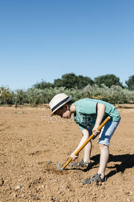 Young gardener plowing the ground — Stock Photo