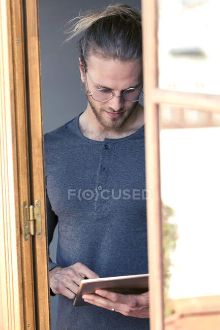 Young man at home using a digital tablet — Stock Photo