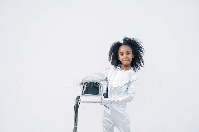Portrait of little girl wearing space suit in front of white background — Stock Photo
