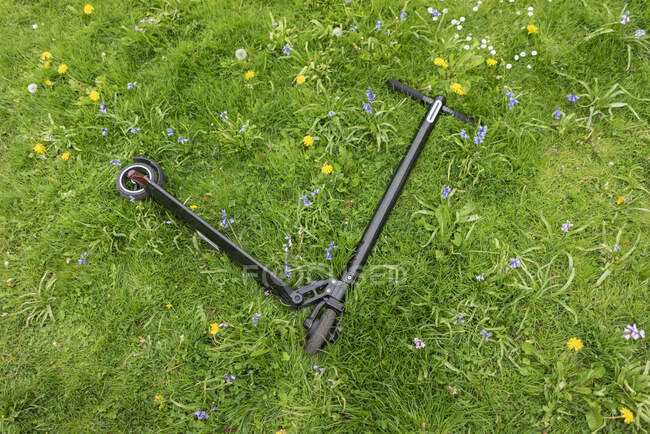 E-Scooter лежить на лузі квітів. — стокове фото