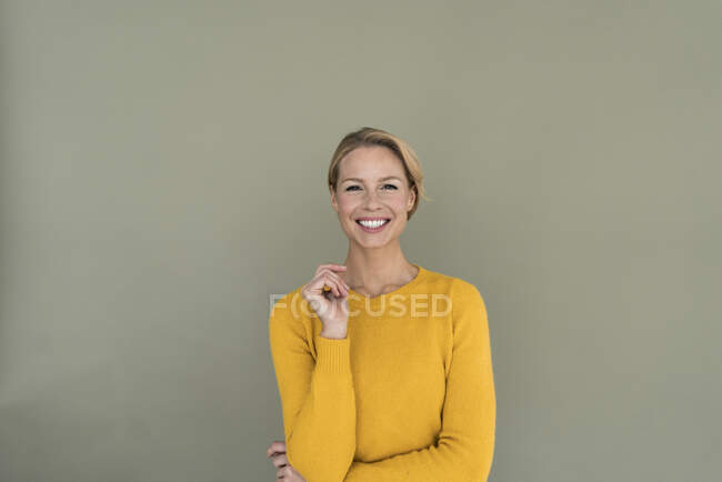 Retrato ov mujer rubia sonriente, usando jersey amarillo - foto de stock