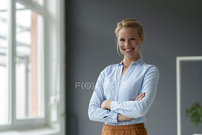 Retrato de una joven empresaria sonriente en el cargo - foto de stock