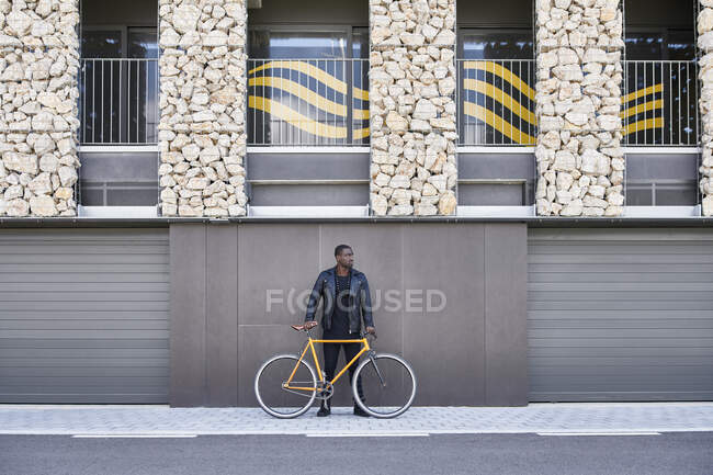 Hombre con bicicleta caminando sobre el pavimento - foto de stock
