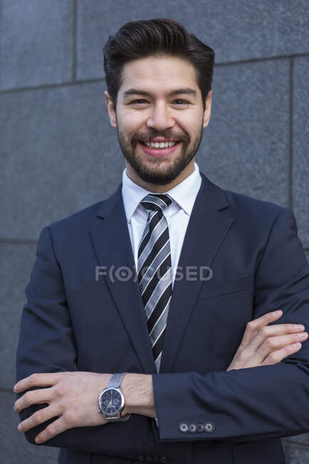 Portrait of bearded young businessman wearing blue suit jacket, tie and wrist watch — Stock Photo