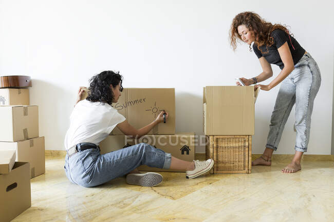 Two friends moving into new home — Stock Photo