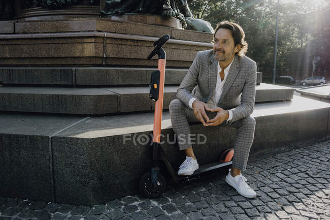 Geschäftsmann mit E-Scooter in der Stadt — Stockfoto