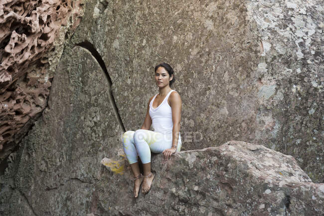 Jovem mulher asiática sentada em uma rocha — Fotografia de Stock