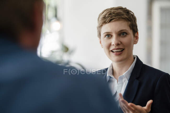 Retrato de una mujer de negocios hablando con un colega - foto de stock