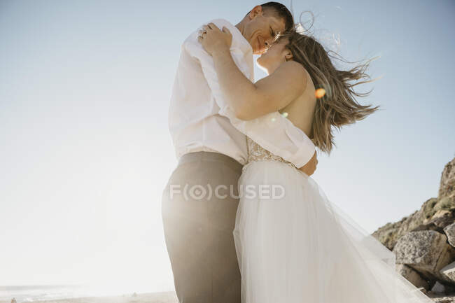 Affettuosi sposi sulla spiaggia al tramonto — Foto stock