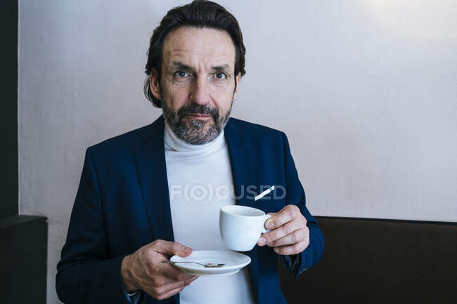 Портрет зрілого бізнесмена з чашкою кави у кафе. — стокове фото