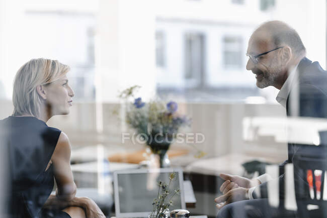 Бизнесмен и женщина встречаются в кофейне, обсуждают работу — стоковое фото