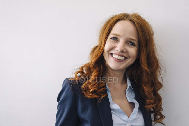 Retrato de una mujer de negocios pelirroja sonriente - foto de stock