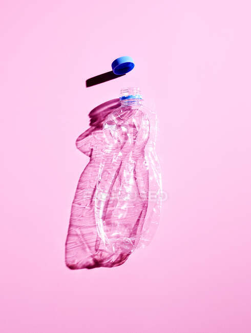 Botella de plástico sobre fondo rosa - foto de stock