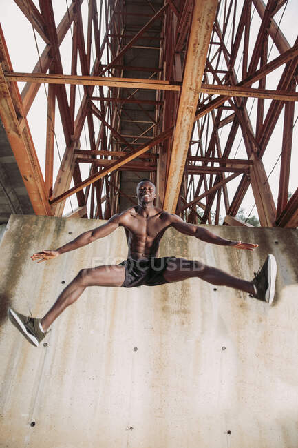 Молодий чоловік біжить під мостом. — стокове фото