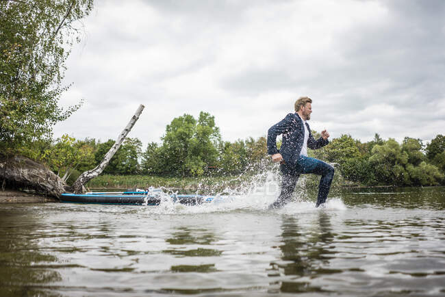 Бізнесмен протікає через озеро. — стокове фото