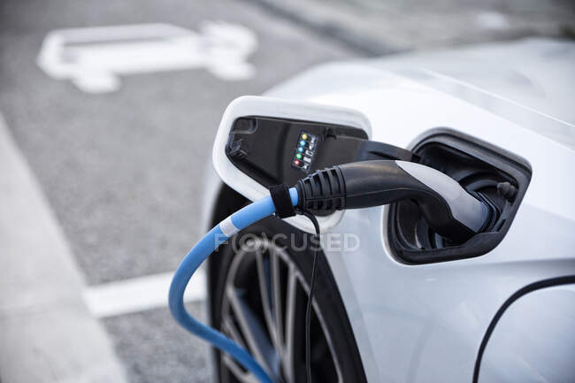 Электрический автомобиль gettig заряжен на зарядной станции — стоковое фото
