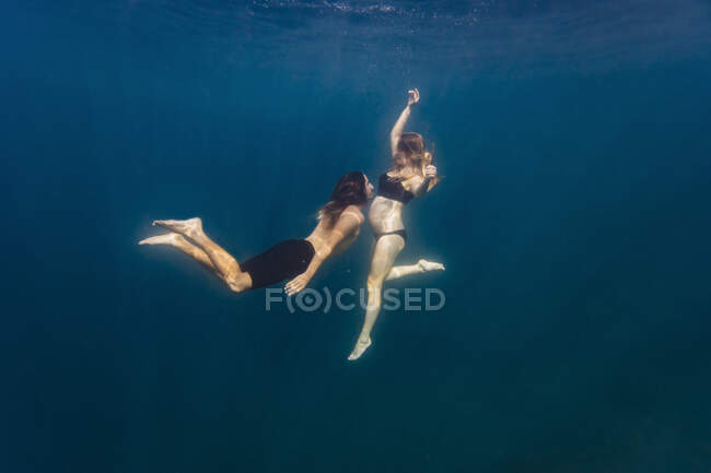 Jeune couple sous l'eau, femme enceinte — Photo de stock