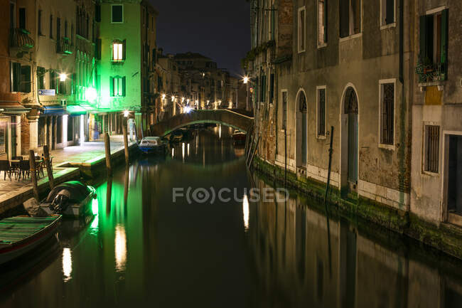 Ponte sul canale tra gli edifici di Venezia di notte — Foto stock
