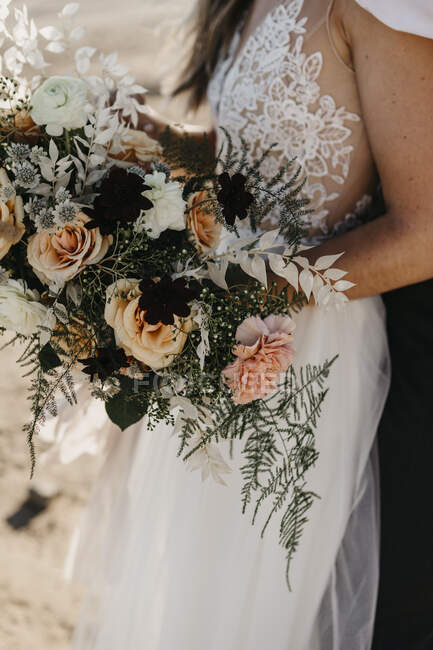 Elegant bride holding bridal bouquet outdoors — Stock Photo