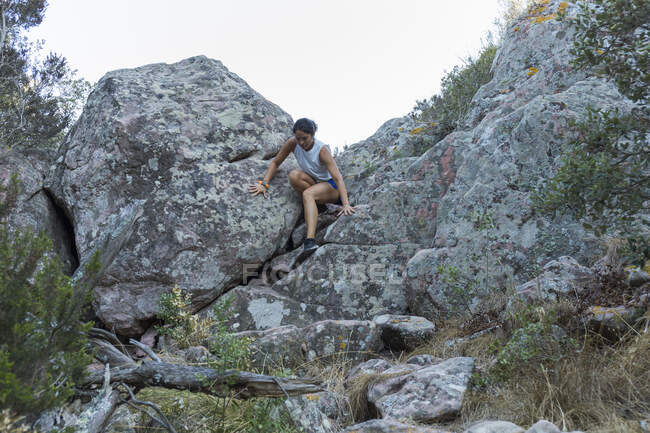 Молодая азиатка, карабкающаяся по скале — стоковое фото