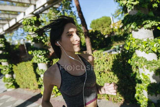 Frau mit Kopfhörern rennt ins Freie — Stockfoto