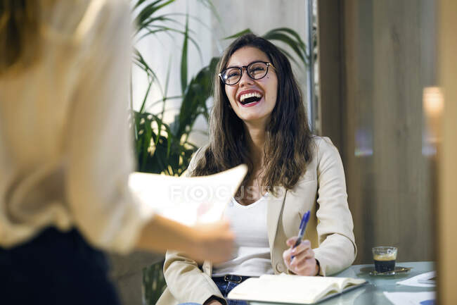 Donna d'affari ridente guardando collega in ufficio moderno — Foto stock