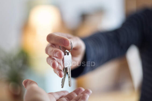 Close-up of hand over of house key in new home — Stock Photo
