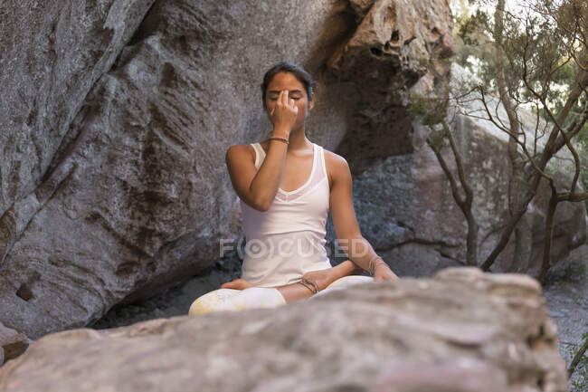Junge Asiatin praktiziert Yoga auf einem Felsen, atmet — Stockfoto