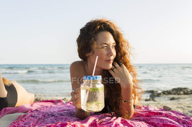 Jeune femme allongée sur la plage — Photo de stock