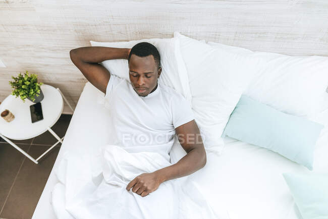 Junger Mann liegt zu Hause im Bett — Stockfoto