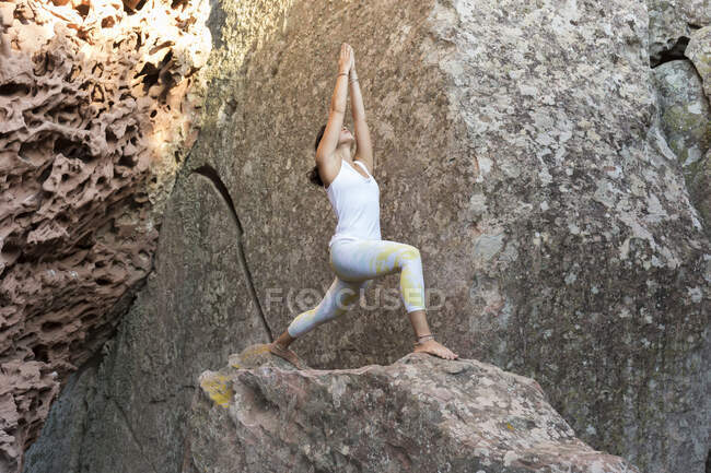 Молодая азиатка, практикующая йогу на скале, позирует воину — стоковое фото