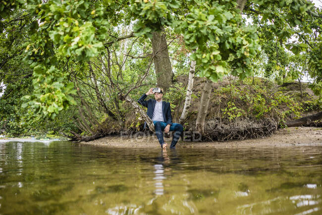 Uomo d'affari in riva al lago con occhiali VR guardando fuori — Foto stock