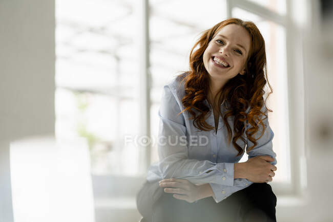 Retrato de mulher ruiva rindo sentado em um sótão — Fotografia de Stock