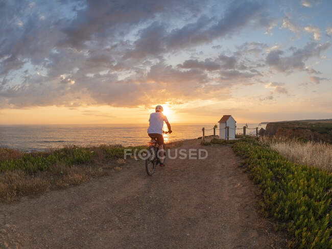 Portugal, Alentejo, senior man on e-bike at sunset — Stock Photo