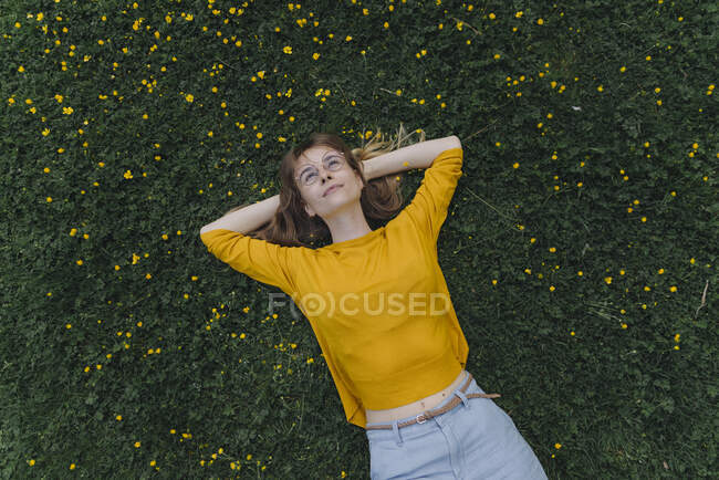 Jovem deitada em um prado de flores — Fotografia de Stock